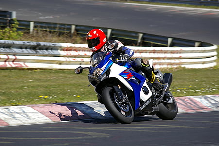 person riding Suzuki GSX-R sports bike on race track at daytime thumbnail