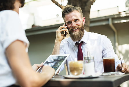 man wearing white dress shirt and maroon necktie sitting by the table thumbnail