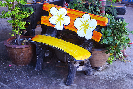 white flower painted on brown bench thumbnail