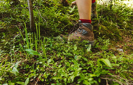 person wearing hiking shoe standing on grass thumbnail