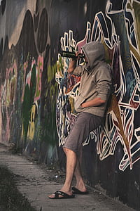 person leaning on wall drinking from bottle thumbnail
