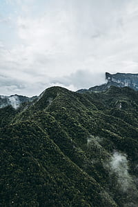 close up photography of peak of mountain under clear white and grey sky thumbnail