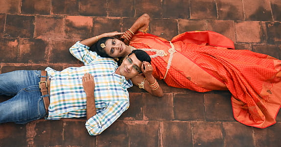 man and woman lying on brown brick surface during daytime thumbnail
