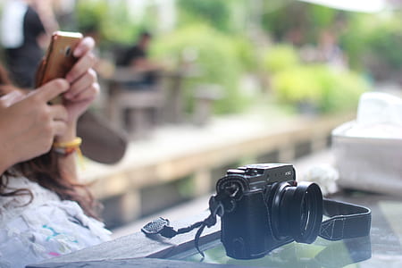 person taking picture of black bridge camera on tabletop thumbnail
