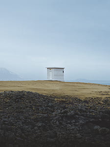 white shed in an open field at daytime thumbnail