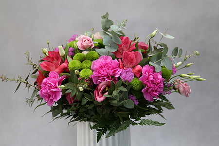 pink, red, and green petaled flowers in white vase close up photo thumbnail