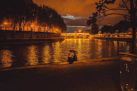 man and woman sitting beside grand canal during night time thumbnail