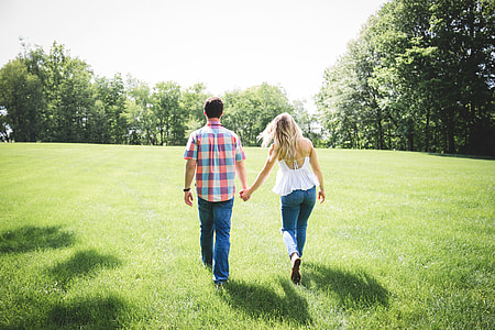 man and woman holding hands while walking thumbnail