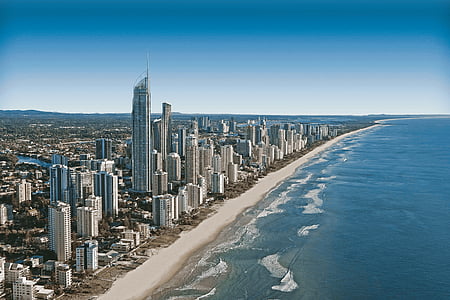 city building near body of water under blue clouds thumbnail