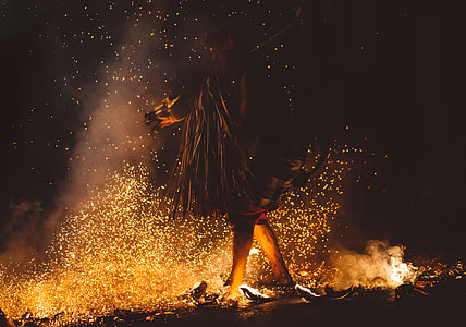 person walking on lit coals on ground thumbnail