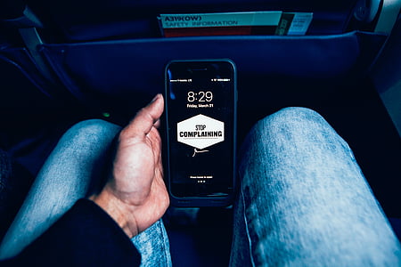 person holding black iPhone inside car thumbnail