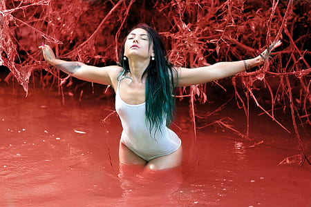 woman wearing white one-piece suit on red body of water thumbnail
