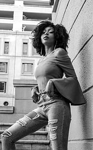 Grayscale Photo of Woman Posing Beside the Wall thumbnail