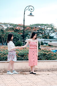 Two Women Holding Hands Under Green Metal Post Lamp thumbnail