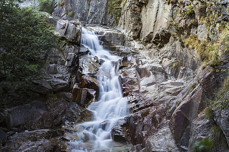 waterfalls below rock mountain thumbnail