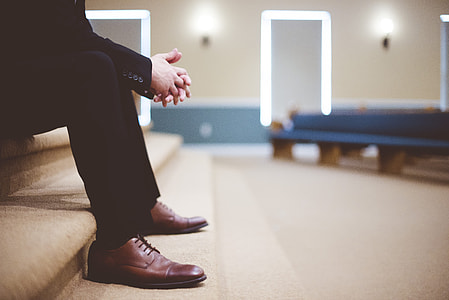 man in black suit sitting on brown stairs thumbnail