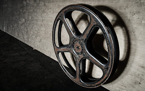 round black and brown metal wheel on grey wooden surface thumbnail