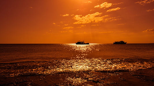 boat in the middle of water beside boat under cloudy sky thumbnail