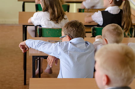 boy sitting near brown table thumbnail