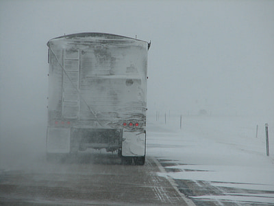 snow-covered trailer truck on road during daytime thumbnail