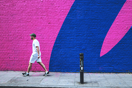 A man walks past a coloured brick wall in East London thumbnail