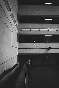 grayscale photo of woman leaning on wall thumbnail