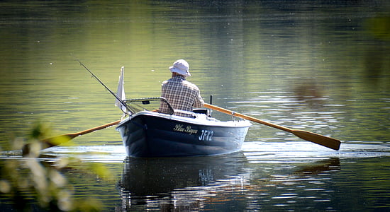 man riding black boat using oar thumbnail