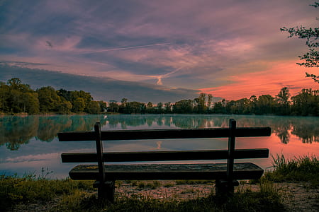 photo of brown wooden bench during sunset thumbnail