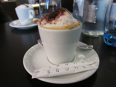 coffee in coffee cup on saucer with sugar packs thumbnail
