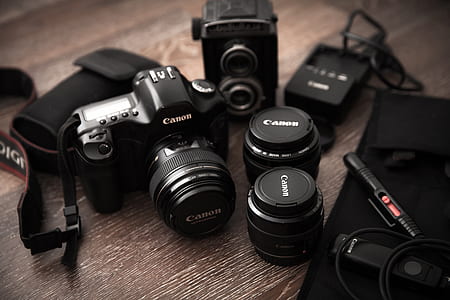 black Canon DSLR camera on brown wooden floor thumbnail