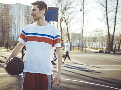Man Wearing Shirt Holding Basketball in Court thumbnail
