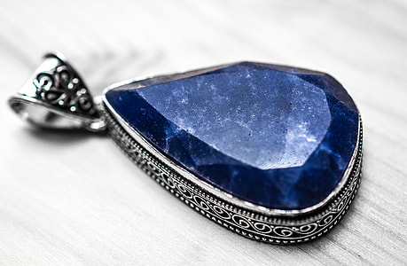 silver and blue pendant on gray wooden table thumbnail