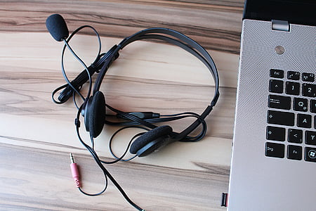 black corded headset beside laptop on table thumbnail