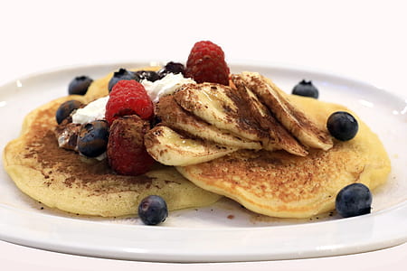 pancake with raspberries and blueberries on white ceramic plate thumbnail
