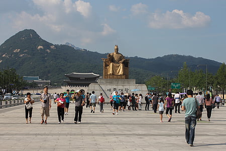 people near gold statue during daytime thumbnail