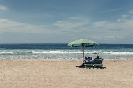 green patio umbrella with sun chairs during daytime thumbnail
