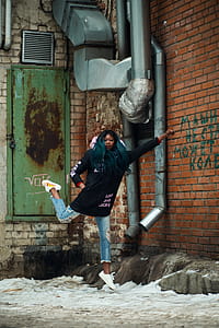 Woman Wearing Black Jacket Near Red Concrete Bricks thumbnail