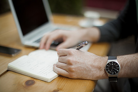 person holding pen writing on table thumbnail