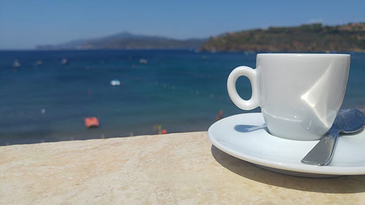 white ceramic teacup on saucer beside spoon thumbnail