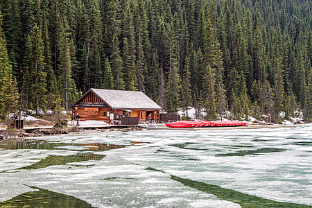 brown log cabin near frozen body of water thumbnail