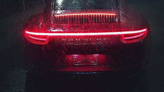red Porsche 911 Carrera GTS taillight turned on during rain thumbnail