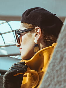 Woman in Yellow Trench Coat, Black Leather Gloves, Black Sunglasses and Black Hat thumbnail