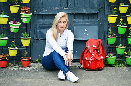 photo of woman in white long-sleeved top and blue jeans sitting down on the floor thumbnail