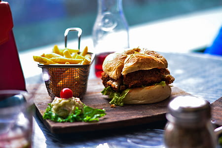 burger and fries served on brown wood slab thumbnail