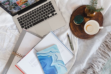 Bed full of pillows and notebooks with Apple gadgets thumbnail