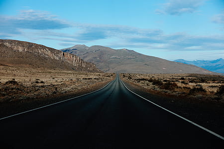 gray concrete road near mountain thumbnail