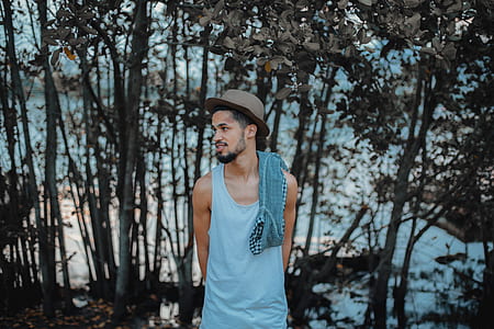 man standing near trees and body of water thumbnail