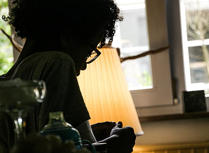 Silhouette of Woman Beside Beige Lampshade Inside White Painted House thumbnail