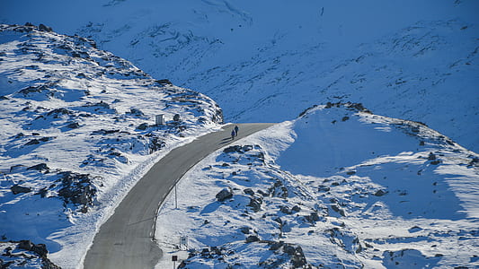 photography of two person walking on road surrounded by snow thumbnail