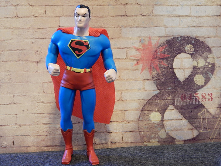 Superman figure in front of brick wall